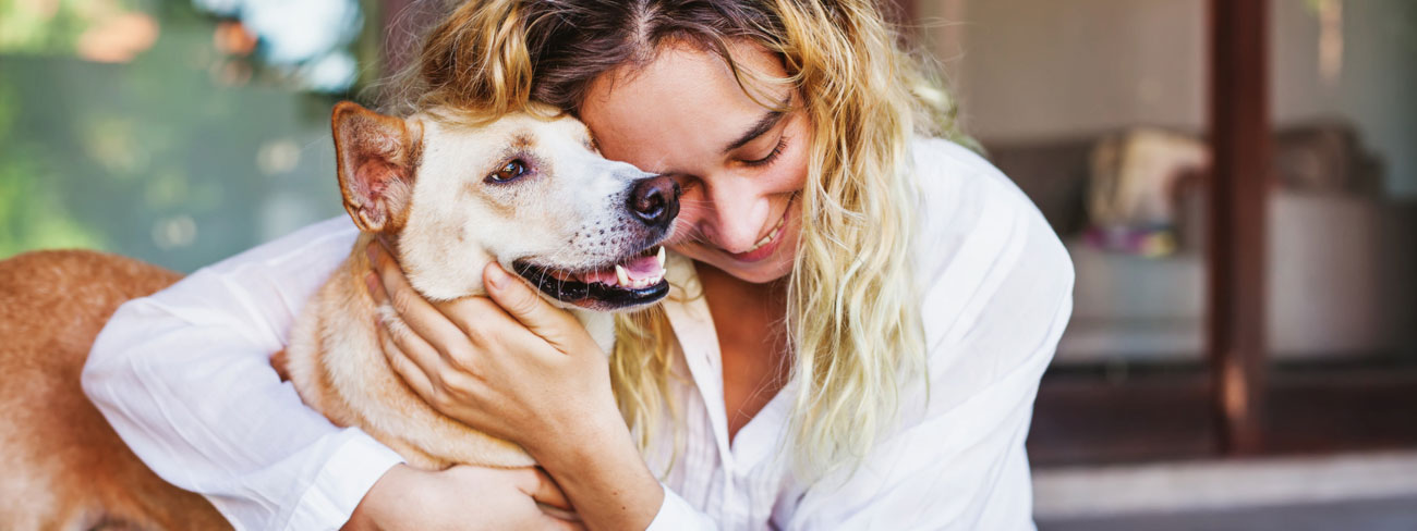 Woman hugging her older dog